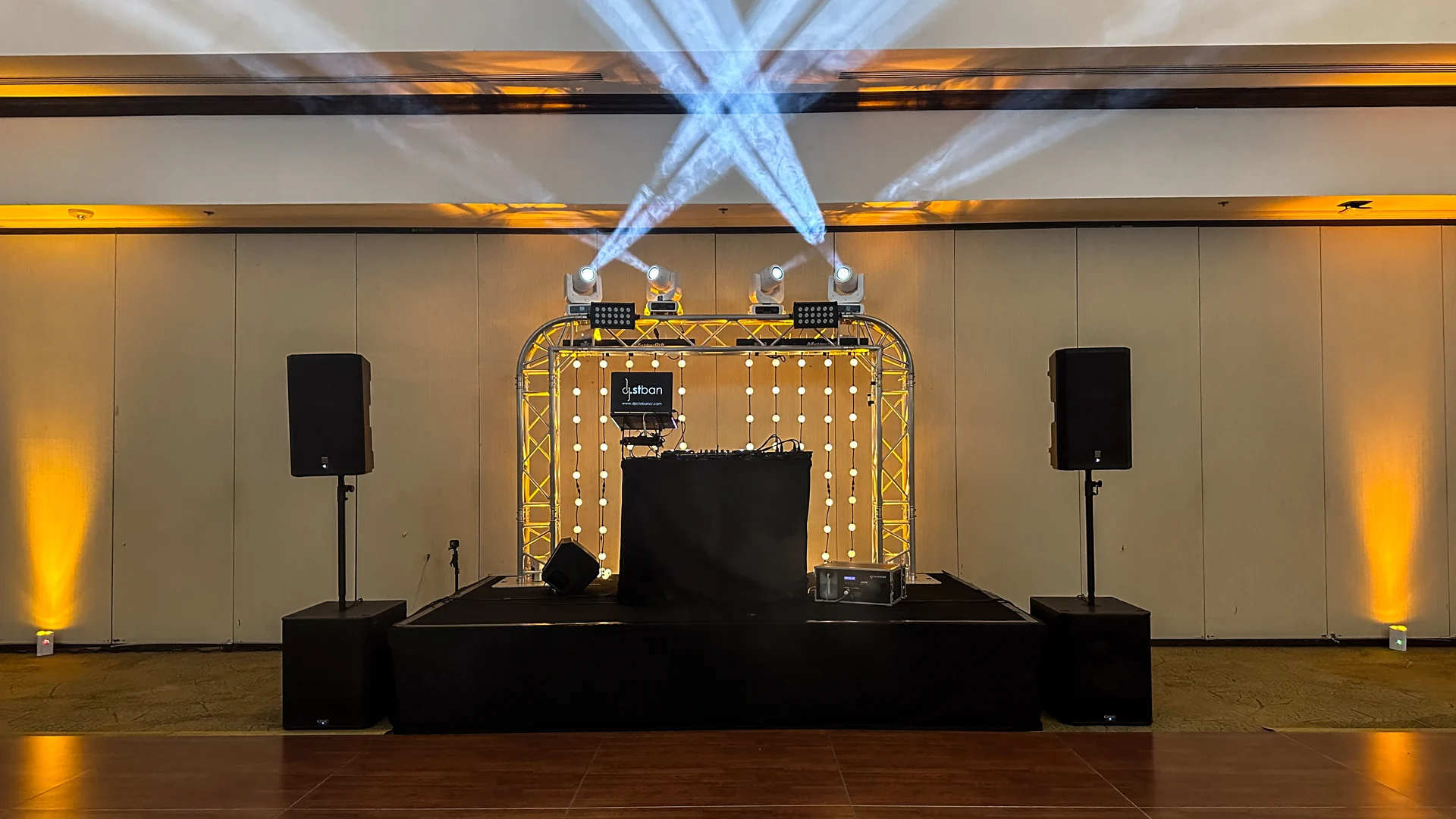 Marco curvo de truss de aluminio con iluminación, montado detrás de una cabina de DJ